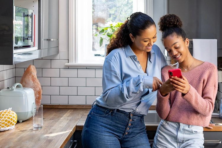 mother and daughter bonding while watching video on social media