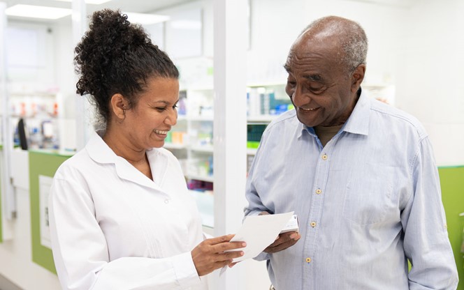 pharmacist helping customer with prescription medicine